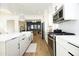 Open concept kitchen with a large island, farmhouse sink, stainless steel appliances, and hardwood floors at 1005 Whistler St, Durham, NC 27713