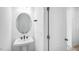 Compact bathroom with a pedestal sink, modern faucet, and a well-lit mirror at 101 Hiddenite Pl, Holly Springs, NC 27540