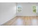 Bright bedroom with two windows and light wood flooring, creating a clean and airy atmosphere at 101 Hiddenite Pl, Holly Springs, NC 27540