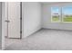 Inviting bedroom with neutral carpet, double windows, and closet space for ample storage at 101 Hiddenite Pl, Holly Springs, NC 27540