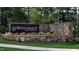 Stone sign for Bridgeberry in Holly Springs surrounded by manicured landscaping and mature trees at 101 Hiddenite Pl, Holly Springs, NC 27540