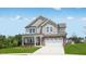 Inviting two-story home with a covered porch, brick accents, and a well-manicured front lawn at 101 Hiddenite Pl, Holly Springs, NC 27540