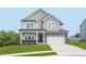 Charming two-story home with a brick-accented facade, landscaped yard, and a two-car garage at 101 Hiddenite Pl, Holly Springs, NC 27540