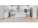 Modern kitchen featuring white cabinets, stainless steel appliances, and a large center island with seating at 101 Hiddenite Pl, Holly Springs, NC 27540