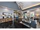 Stylish living room featuring modern furnishings, a unique chandelier, and ample seating at 101 Hiddenite Pl, Holly Springs, NC 27540