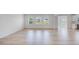 Spacious living room featuring light wood flooring and three large windows overlooking the backyard at 101 Hiddenite Pl, Holly Springs, NC 27540