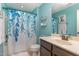 Cozy bathroom features a shower with a decorative curtain, a sink with vanity, and blue walls at 1018 Tranquil Creek Way, Wake Forest, NC 27587