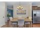 Cozy dining area with a wooden table, four chairs, and stainless steel refrigerator at 1018 Tranquil Creek Way, Wake Forest, NC 27587