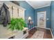 Charming entryway with blue walls, coat rack, and decorative plant on top of a shoe rack at 1018 Tranquil Creek Way, Wake Forest, NC 27587
