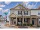 Charming townhome features a stone facade, inviting front porch, and well-manicured landscaping at 1018 Tranquil Creek Way, Wake Forest, NC 27587