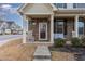 Inviting front porch features stone accents, and comfortable seating area with decorative plants at 1018 Tranquil Creek Way, Wake Forest, NC 27587