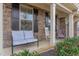 Inviting front porch features stone accents, and comfortable seating area with decorative plants at 1018 Tranquil Creek Way, Wake Forest, NC 27587