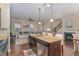 A stylish kitchen features an island with a sink, granite countertops and a view into the living room at 1018 Tranquil Creek Way, Wake Forest, NC 27587