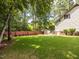Green backyard featuring a shed and a charming red fence at 104 Pinecroft Dr, Raleigh, NC 27609