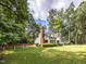 Charming home with spacious lawn, and driveway that is surrounded by trees at 104 Pinecroft Dr, Raleigh, NC 27609