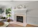Cozy living room fireplace with white mantel and hearth, perfect for relaxation at 104 Pinecroft Dr, Raleigh, NC 27609