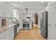 Modern kitchen with stainless appliances, white cabinets, and a stylish vent hood at 104 Pinecroft Dr, Raleigh, NC 27609