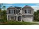 Charming two-story home with gray siding, black shutters, and well-manicured front yard at 109 Hiddenite Pl, Holly Springs, NC 27540