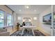 Well-lit home office with large windows, hardwood floors, and modern furnishings at 109 Hiddenite Pl, Holly Springs, NC 27540