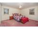 Bedroom showcasing pink carpet, windows, and a bed with a colorful quilt at 1103 Driftwood Dr, Siler City, NC 27344
