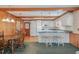 Charming eat-in kitchen featuring white cabinets, wood paneling, breakfast bar and seamless access to living spaces at 1103 Driftwood Dr, Siler City, NC 27344