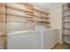 Functional laundry room with shelving and appliances, providing convenience at 1103 Driftwood Dr, Siler City, NC 27344