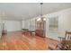 Spacious living room featuring hardwood floors, a chandelier, and ample natural light from large windows at 1103 Driftwood Dr, Siler City, NC 27344