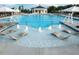 Leisure pool featuring tanning chairs in shallow water with splash features, surrounded by umbrellas and lounge chairs at 113 Hardy Oaks Way, Holly Springs, NC 27540