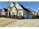 Beautiful exterior showcasing a well-maintained lawn, a two-car garage, and complementary siding with architectural flair at 113 Hardy Oaks Way, Holly Springs, NC 27540