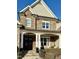 Charming front porch with stone accents, decorative columns, and cozy seating, perfect for relaxing outdoors at 113 Hardy Oaks Way, Holly Springs, NC 27540