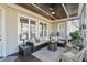 Inviting screened porch featuring comfortable furniture, ceiling fan, and stylish decor at 113 Hardy Oaks Way, Holly Springs, NC 27540