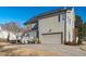 Side view of a two story home with a two car garage, backyard deck, and neutral colored exterior at 114 Lansbrooke Ln, Apex, NC 27502