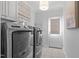 Well-lit laundry room with modern washer and dryer units and ample cabinet space at 114 Lansbrooke Ln, Apex, NC 27502