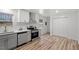 Well-lit kitchen featuring stainless steel appliances, white cabinets, and wood-look floors for a modern, clean design at 120 King Charles Rd, Hillsborough, NC 27278