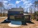 Back view of a home showcases a screened porch and patio, surrounded by a wooded area at 148 Evington Dr, Pittsboro, NC 27312