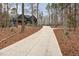 Long driveway leading to a luxury two-story home nestled among mature trees at 148 Evington Dr, Pittsboro, NC 27312