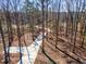Sunlit driveway winds through a wooded landscape, creating a private entrance to the home at 148 Evington Dr, Pittsboro, NC 27312