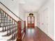 Inviting foyer with hardwood floors, a staircase with dark wood accents and a decorative light fixture at 148 Evington Dr, Pittsboro, NC 27312
