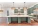 Modern kitchen featuring a large center island, custom green cabinetry, and stainless steel appliances at 148 Evington Dr, Pittsboro, NC 27312