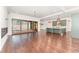 Bright open-concept living room with hardwood floors, expansive windows, and a modern kitchen with green cabinets at 148 Evington Dr, Pittsboro, NC 27312
