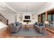 Spacious living room with hardwood floors, a modern fireplace, built-in shelves, and outdoor access at 148 Evington Dr, Pittsboro, NC 27312