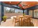 Inviting screened patio featuring wood ceiling, ceiling fan and dining set, providing seamless indoor-outdoor living at 148 Evington Dr, Pittsboro, NC 27312