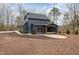 Rear exterior reveals a covered deck, dark trim, and meticulous landscaping with mulch and stone at 148 Evington Dr, Pittsboro, NC 27312