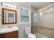 Cozy bathroom features a wood vanity, neutral tiling, and a shower-tub combo with glass doors at 1512 Maybrook Dr, Raleigh, NC 27610