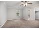 Neutral bedroom with a ceiling fan, carpeted floor, and ensuite bathroom at 1512 Maybrook Dr, Raleigh, NC 27610