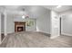 Bright living room featuring a cozy fireplace, ceiling fan and lots of natural light through the windows at 1512 Maybrook Dr, Raleigh, NC 27610