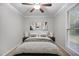 Bright main bedroom with a cozy bed, ceiling fan, a large window, and decorative artwork at 1512 Maybrook Dr, Raleigh, NC 27610