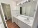 Bathroom featuring double sinks, white cabinetry, walk-in shower and vinyl wood flooring at 1515 Indian Camp Rd, Chapel Hill, NC 27516