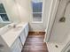 Bathroom featuring white vanity, wood grain floors, shower, and a window that offers natural light at 1515 Indian Camp Rd, Chapel Hill, NC 27516