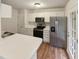 Galley kitchen features white cabinets, stainless steel appliances, and door to backyard at 1515 Indian Camp Rd, Chapel Hill, NC 27516